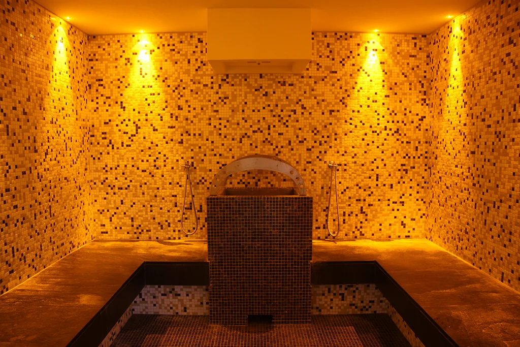 Sauna della SPA con mosaico sulle pareti e luci gialle